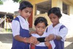 HP Group of school children looking at a mobile in Inida