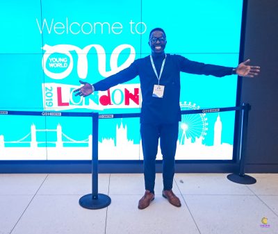 Ogweno Stephen stands in front of a blue screen.